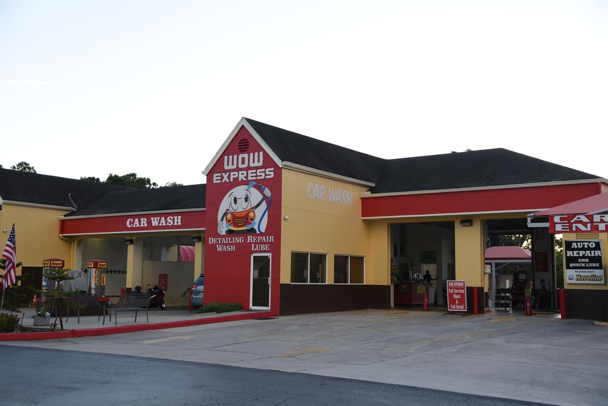 The Wow Express mascot mural — Detailing, Wash, Repair, Lube — on the car wash building